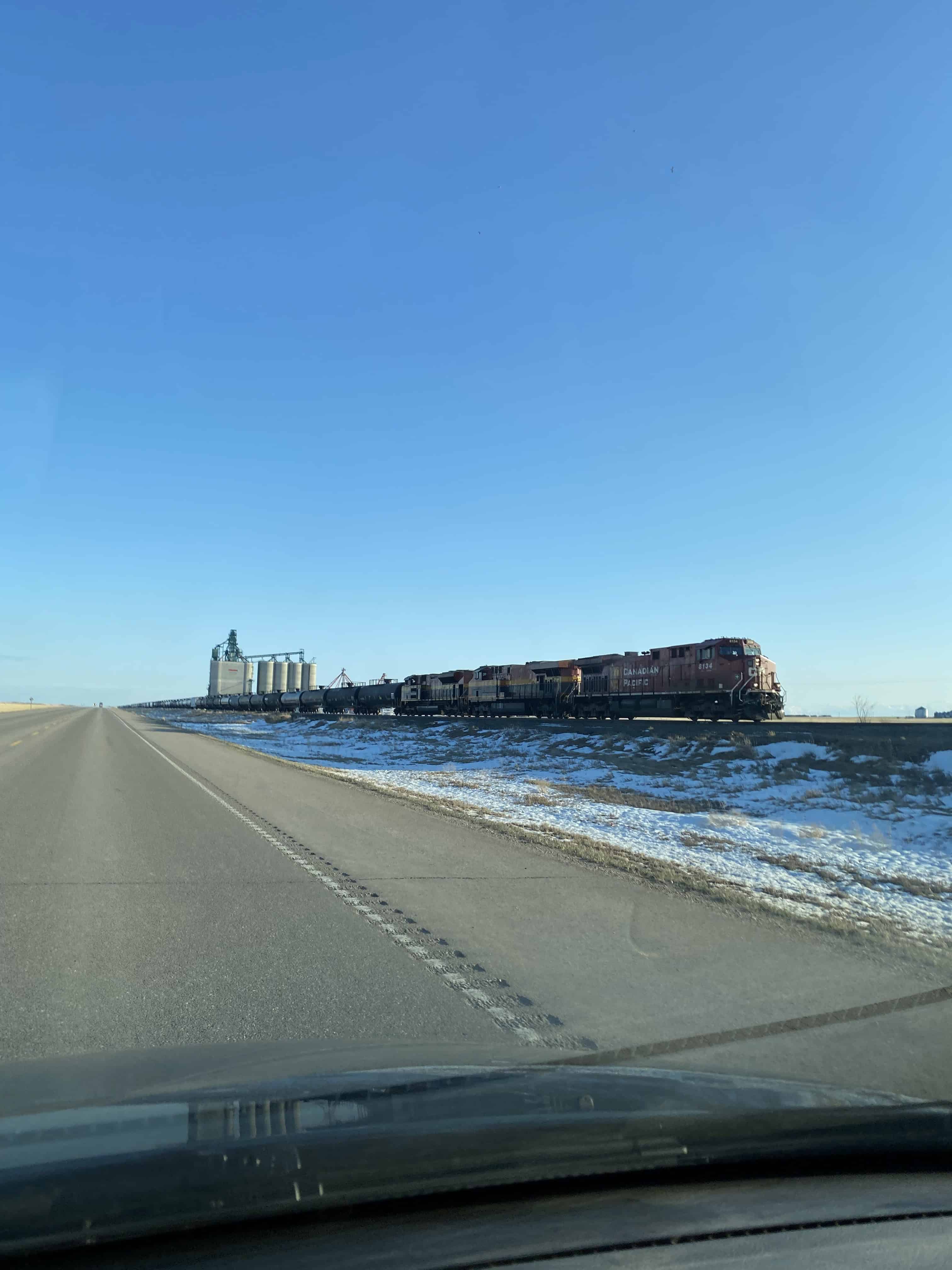 A picture of a CPKC freight train rolling through the Canadian prairies.
